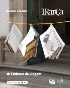 Imagem ilustrativa do «Caderno de Viagem» - 3 cadernos pendurados pela argola num fio amarelo, à entrada do teatro. As páginas do caderno esvoaçam com o vento.